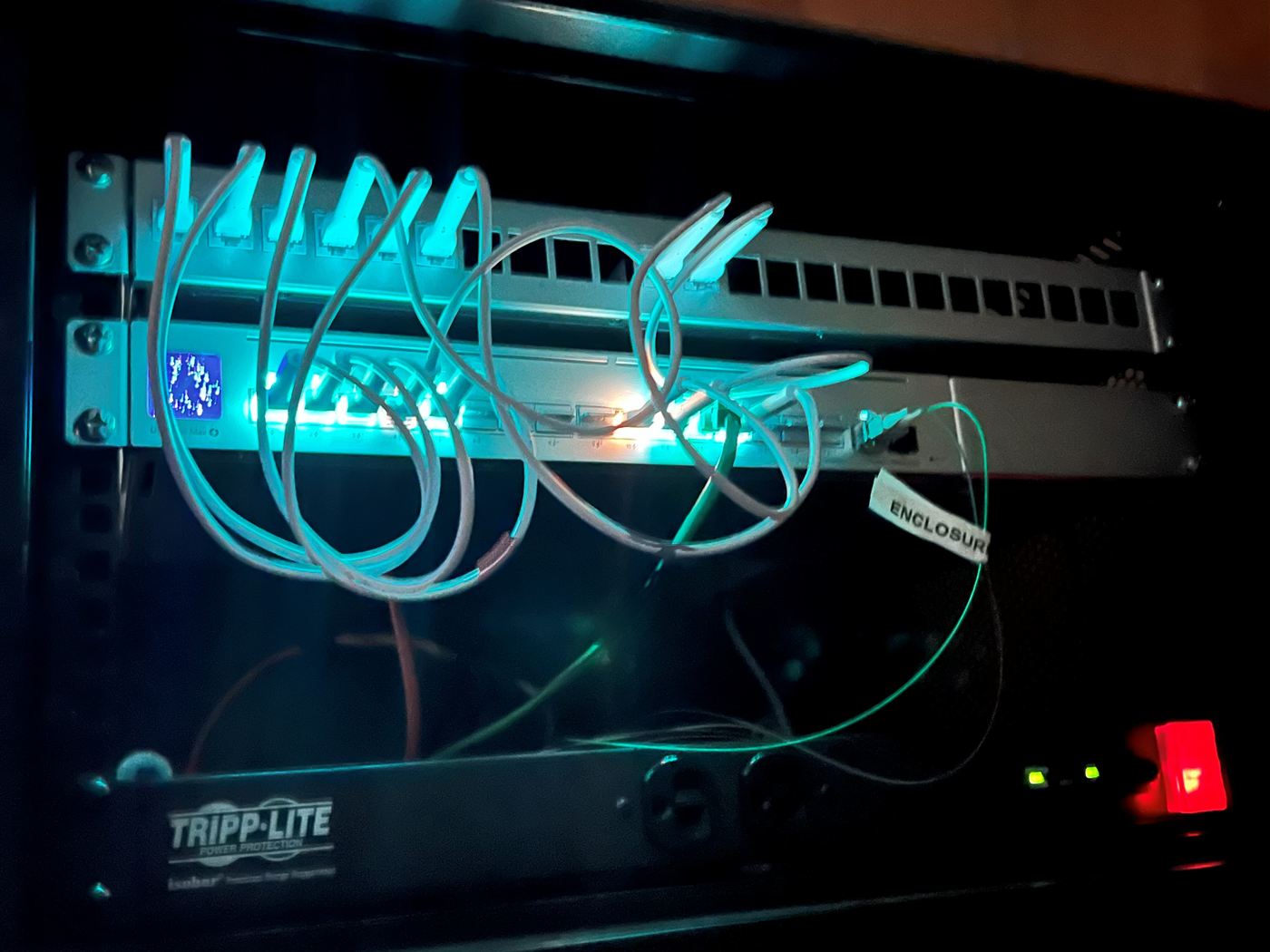 A rack-mounted switch and patch panel with lit ports, installed and managed by Unified Telecom