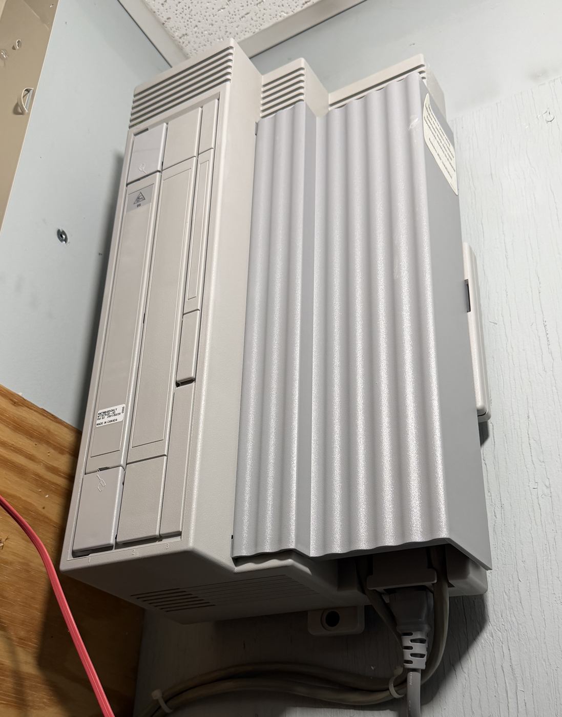 Legacy wall-mounted phone system cabinet next to a punch-down block
