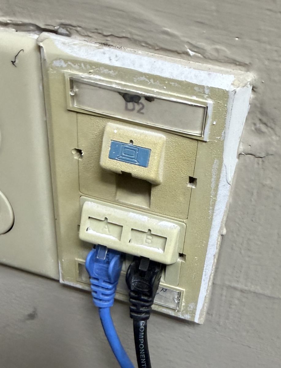 Old, damaged wall plate with unlabeled data jacks